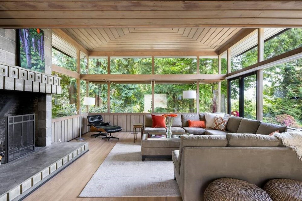 The prominent living room features a vaulted ceiling, transom windows and a large fireplace. | Courtesy of Sue Scott 
