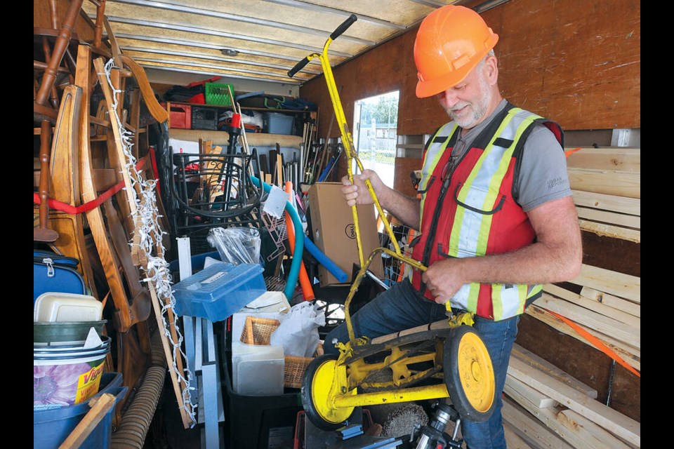Urban Repurpose’s founder Tom Reissner shows off salvagable push mower saved moments before it was dumped at the North Shore Recycling and Waste Centre. | Paul McGrath / North Shore News 