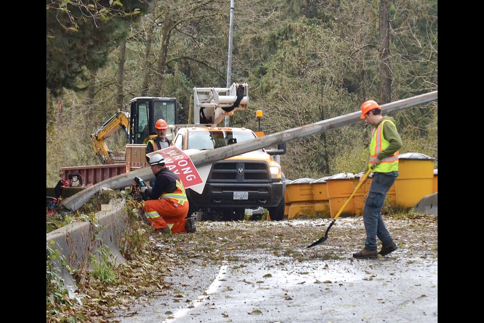 Crews clear the westbound Lynn Valley exit off Highway 1 in North Vancouver after gusty winds caused a tree to fall and knock down a light pole blocking the exit Friday morning. The blockage was cleared before noon. | Paul McGrath / North Shore Ƶapp 