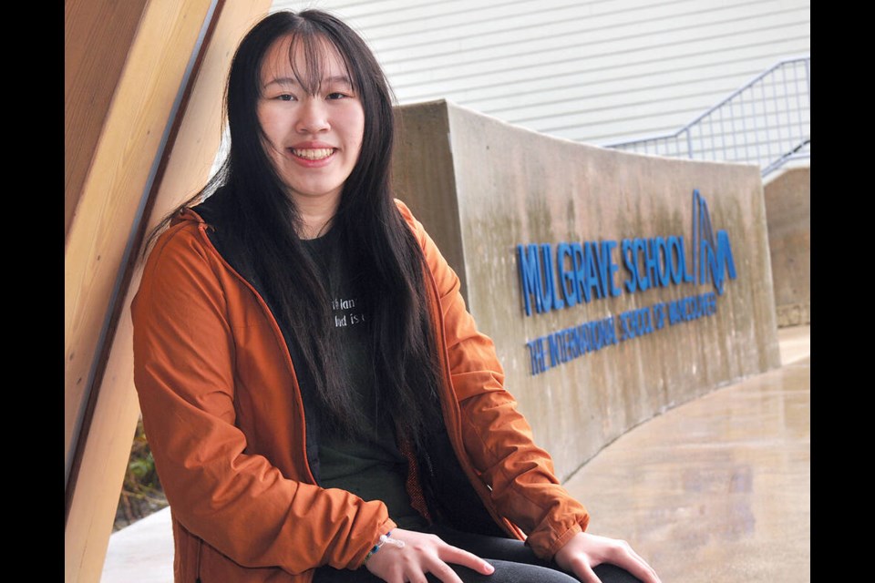 Grade 11 Mulgrave School student Lily YangLiu sitting outside celebrating she has been named among the top 25 women of influence in Canada for her climate advocacy work. | Paul McGrath / North Shore News 