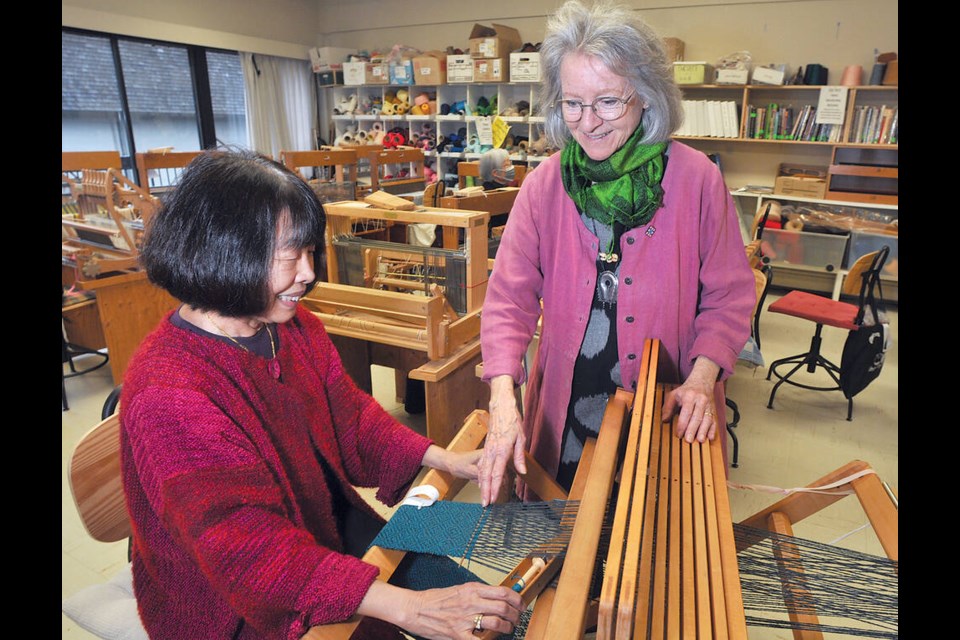 Ferne Louie (left) gets some weaving tips from instructor Toby Smith at Silver Harbour Seniors Centre. They are both wearing outfits they created. A Slow Fashion Show will take place at the centre Saturday April 12 from 1 to 3 pm. | Paul McGrath / North Shore News 