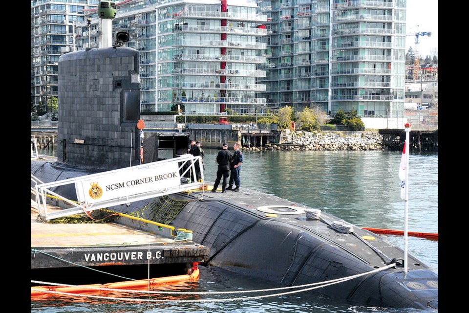 Two members of the Royal Canadian Navy stand on top of HMCS Corner Brook submarine in North Vancouver. | Paul McGrath / North Shore News 