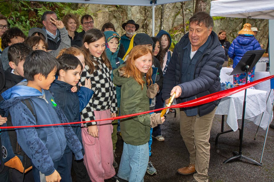 West Vancouver Mayor Mark Sager and Eagle Harbour Montessori School poet Pavlina Hladik cut a ribbon to commemorate the Eagleridge Lands park dedication. | Nick Laba / North Shore News 