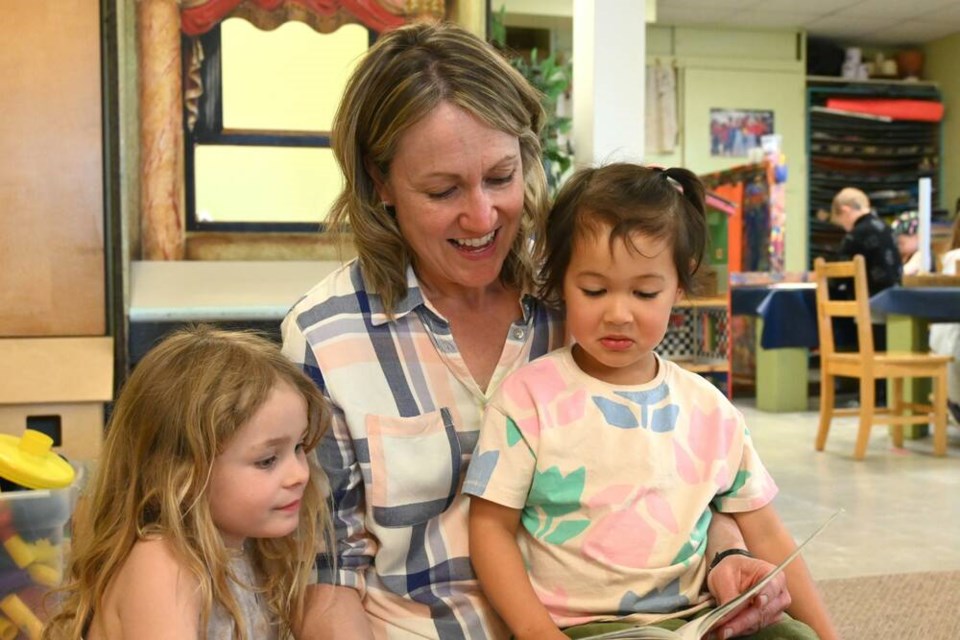 Lead teacher for Upper Lonsdale Preschool Erin Tommasi reads a picture book with two of her students. | Abby Luciano / North Shore News 