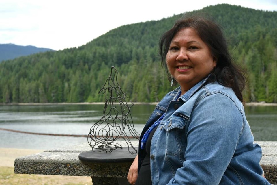 Tsleil-Waututh Nation councillor Charlene Aleck sits on a bench with a wolf sculpture near the water at Barnet Marine Park in Burnaby after signing a co-management agreement with the City of Burnaby. | Abby Luciano / North Shore News 