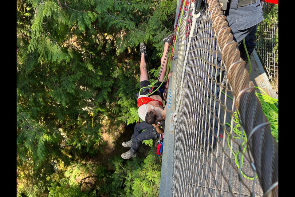 District of North Vancouver Fire and Rescue Services pull an injured cliff jumper up to Lynn Canyon suspension bridge, Sunday evening. | Pat Bell 