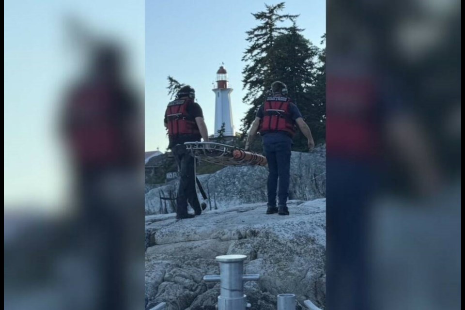 Royal Canadian Marine Search and Rescue crew members carry a stretcher to save an injured hiker at Lighthouse Park in West Vancouver on Wednesday, July 16. | Shane Austin 