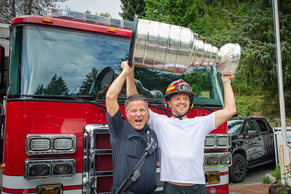 West Vancouver Fire & Rescue Cpt. Jason Leduc hoists the Stanley Cup with NHL superstar Sam Reinhart, as he toured his hometown on Monday. | Nick Laba / North Shore News 