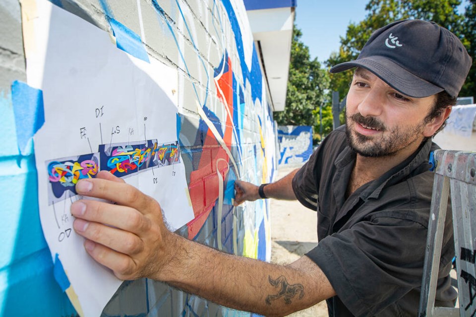 Artist Andrew Tavukciyan works off a plan to complete his mural a the Ambleside Skatepark in West Vancouver, on Tuesday, Aug. 26. | Nick Laba / North Shore News 