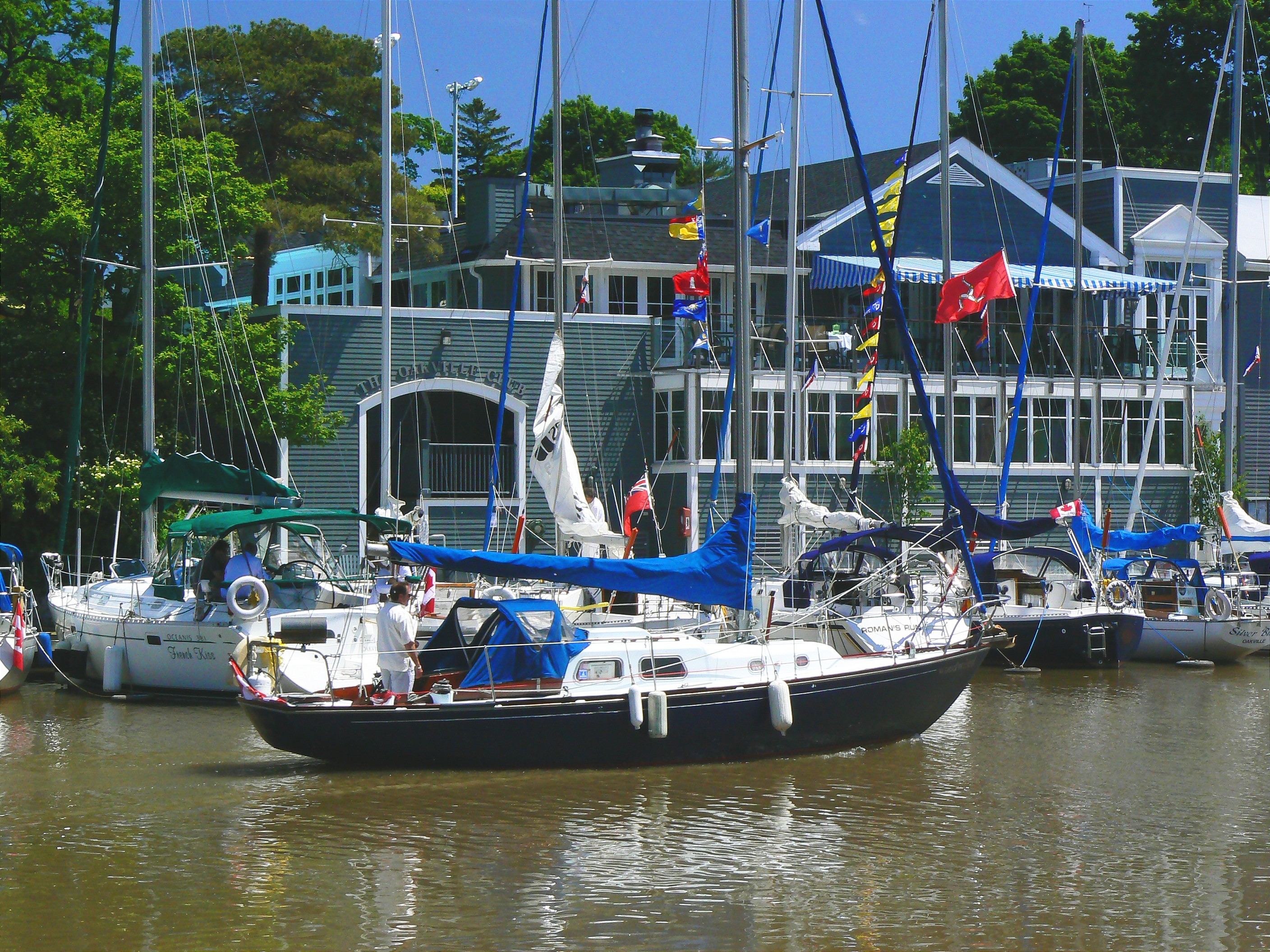 Sail boat on the sixteen mile creek with the Oakville Club in the background