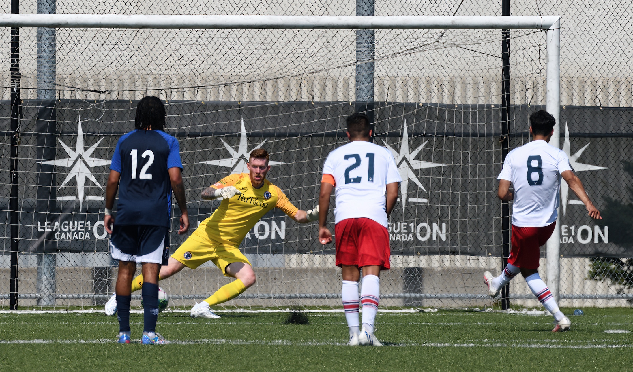 The lead becomes insurmountable. | League1 Ontario Co-Leading scorer Massimo Ferrin sends Blue Devils goalkeeper Luke Birnstingl the wrong way, on a penalty as the Azzurri take a 3 goal lead in the first half. | Bob Twidle