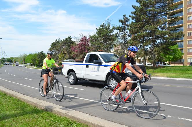 two cyclists on bike lane beside town truck | Town of Oakville