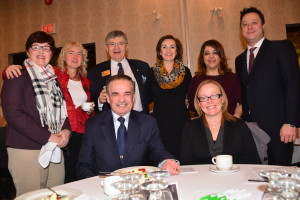 group of people sitting and standing around a table dressed in suits | Cogeco Canada & Oakville Chamber of Commerce supporters at the RBC Economic Update for 2016 which took place on January 27, 2016 in Oakville, Ontario. Photo Credit: Janet Bedford | Janet Bedford