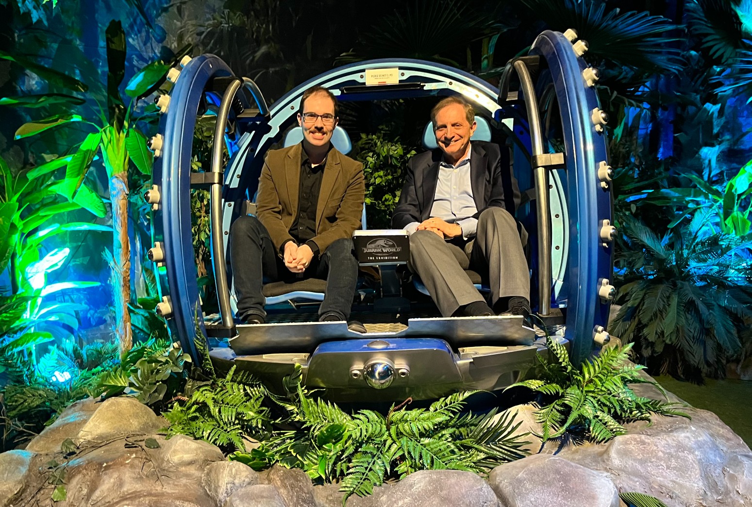Oakville News reporter Tyler Collins (left) with Universal Experiences and Destinations Global President Micheal Silver (right), seen in a Gyrosphere from the film "Jurassic World".
