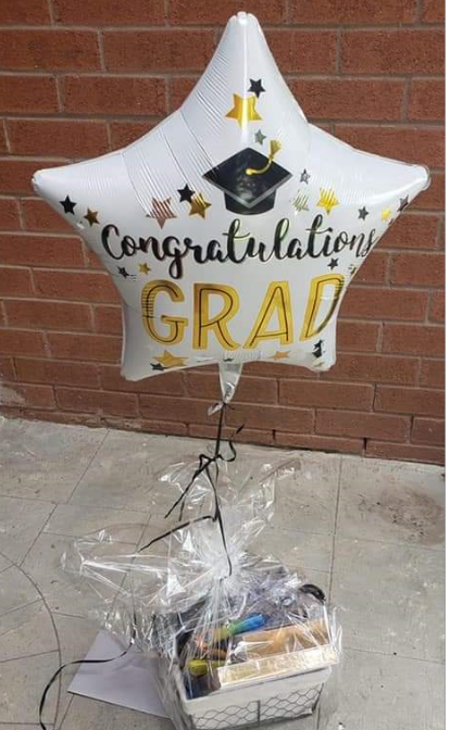 A congratulatory gift basket is dropped off on the porch to surprise the Grad student | Oakville Grade 8 Grad Ninjas group