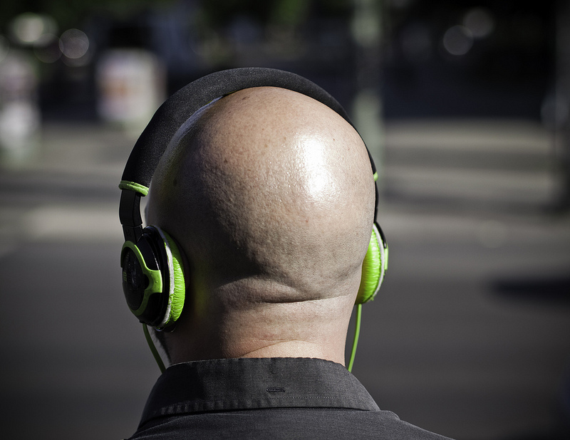 back of bald head with green headphones on | kohlmann.sascha  -  Foter  -  CC BY-SA