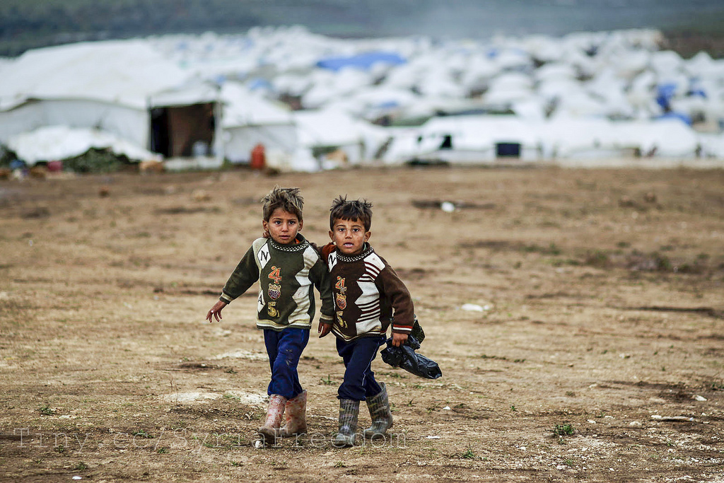 Syrian boys, whose family fled their home in Idlib, walk to their tent, at a camp for displaced Syrians, in the village of Atmeh, Syria, | FreedomHouse via Foter.com  -  CC BY