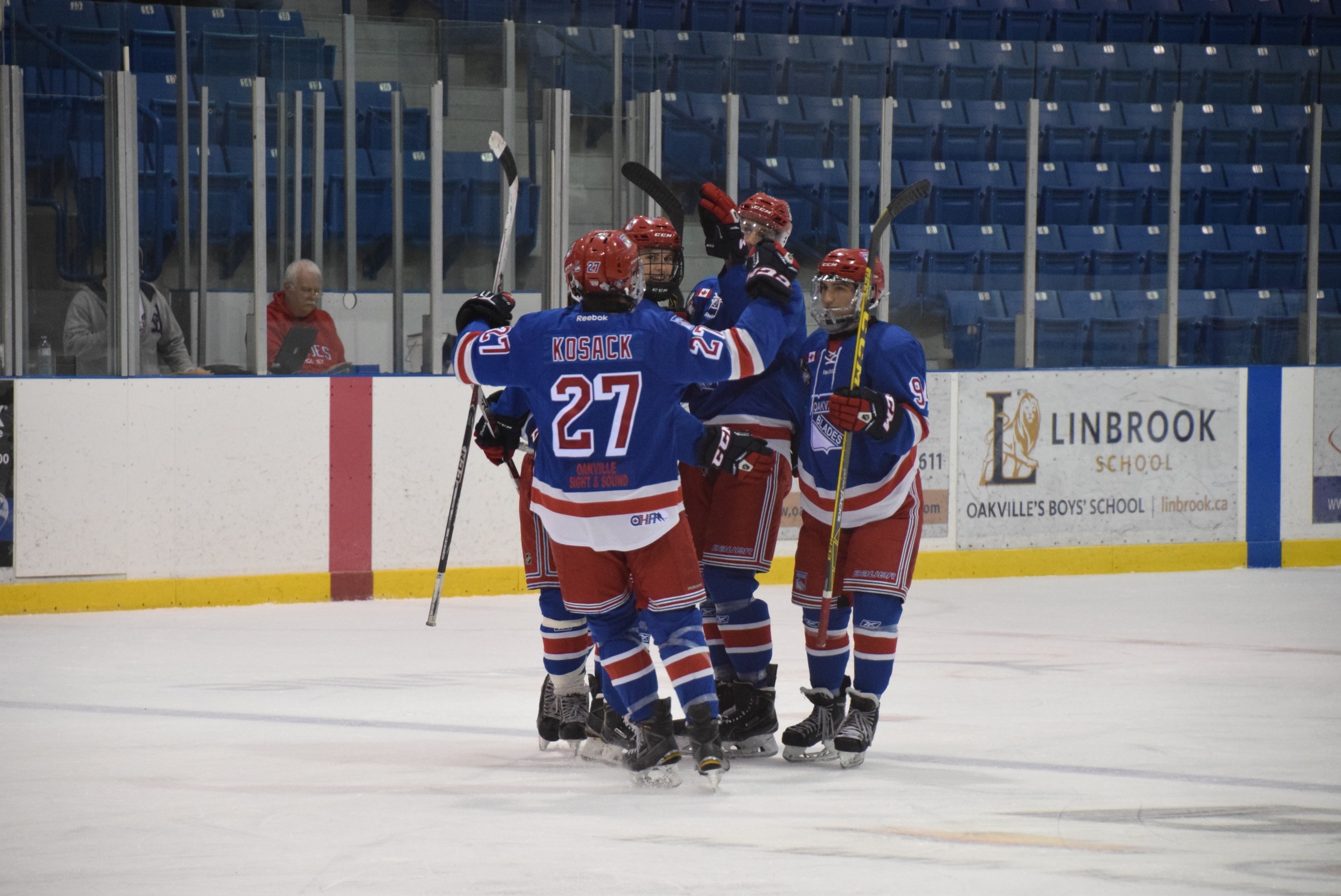 Oakville Blade players on the ice celebrating a goal |  Scott Ellis - The Hockey House
