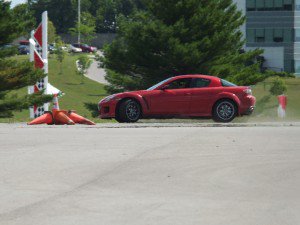red sports car by fallen traffic cones