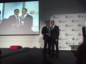 two white males in suits on a stage | Eric Correia (GE Water) and Brad Park (United Way Oakville) at the Celebration of supporters on February 9, 2016. Photo Credit: United Way Oakville | United Way Oakville