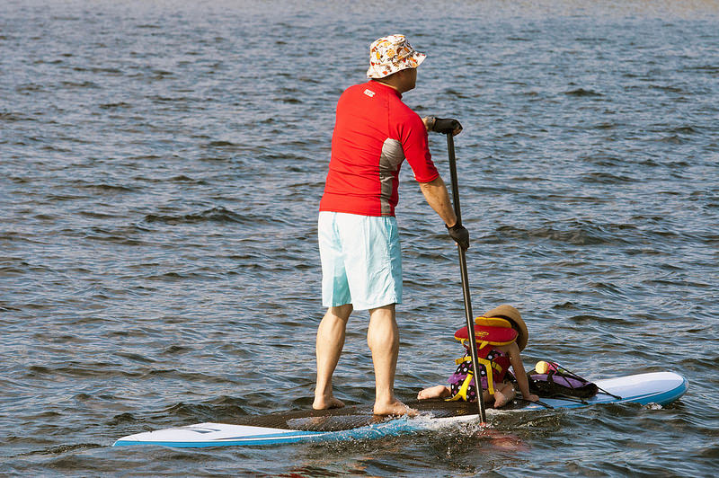 Man paddle boarding with his baby daughter | Hammerin Man  -  Foter  -  CC BY