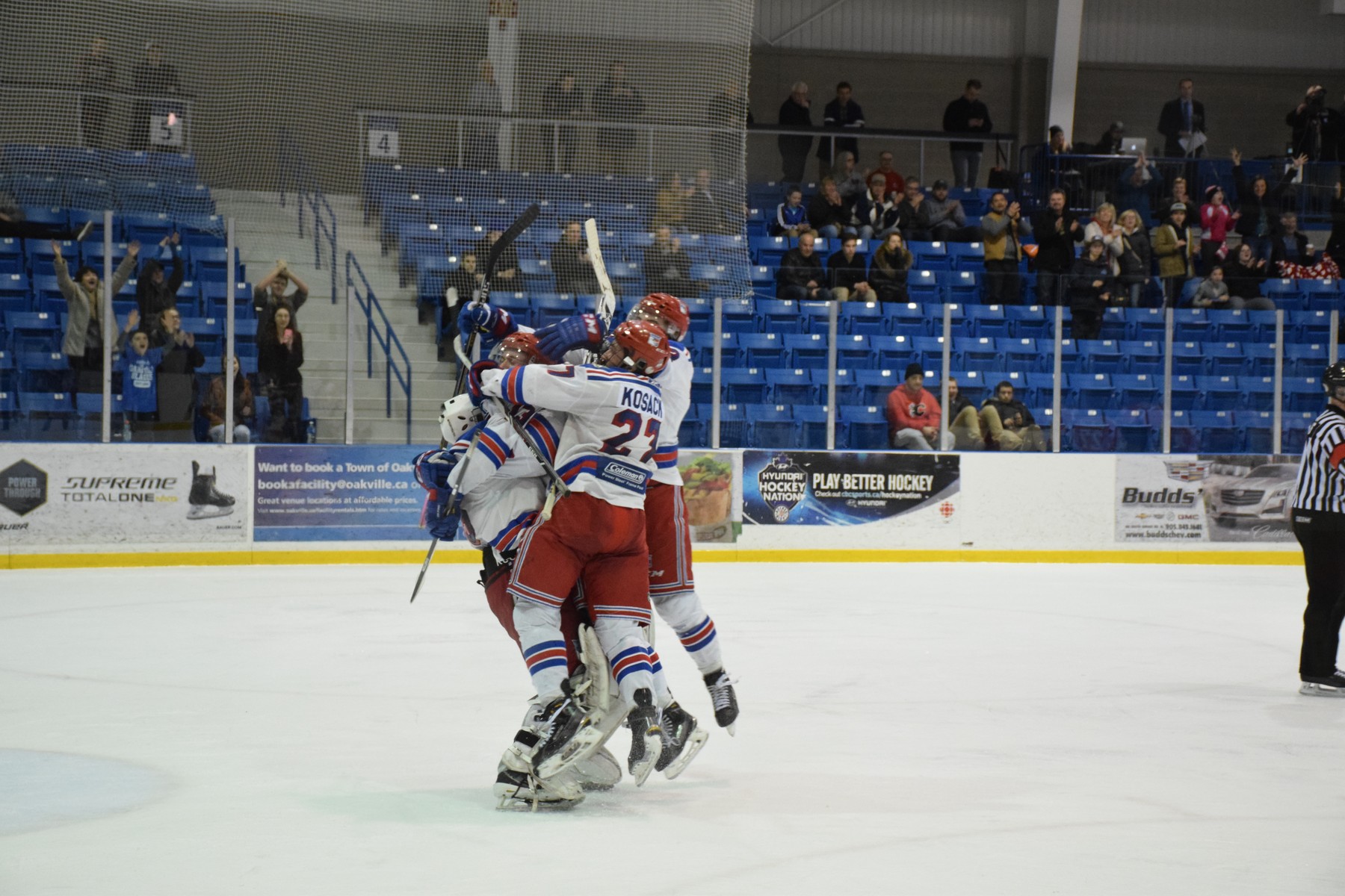 Oakville Blades in a congratulatory group hug | Scott Ellis - The Hockey House