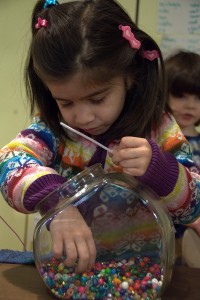 Girl picking beads |  Beading is just one of the activities available at the Oakville Museum this March Break 2015