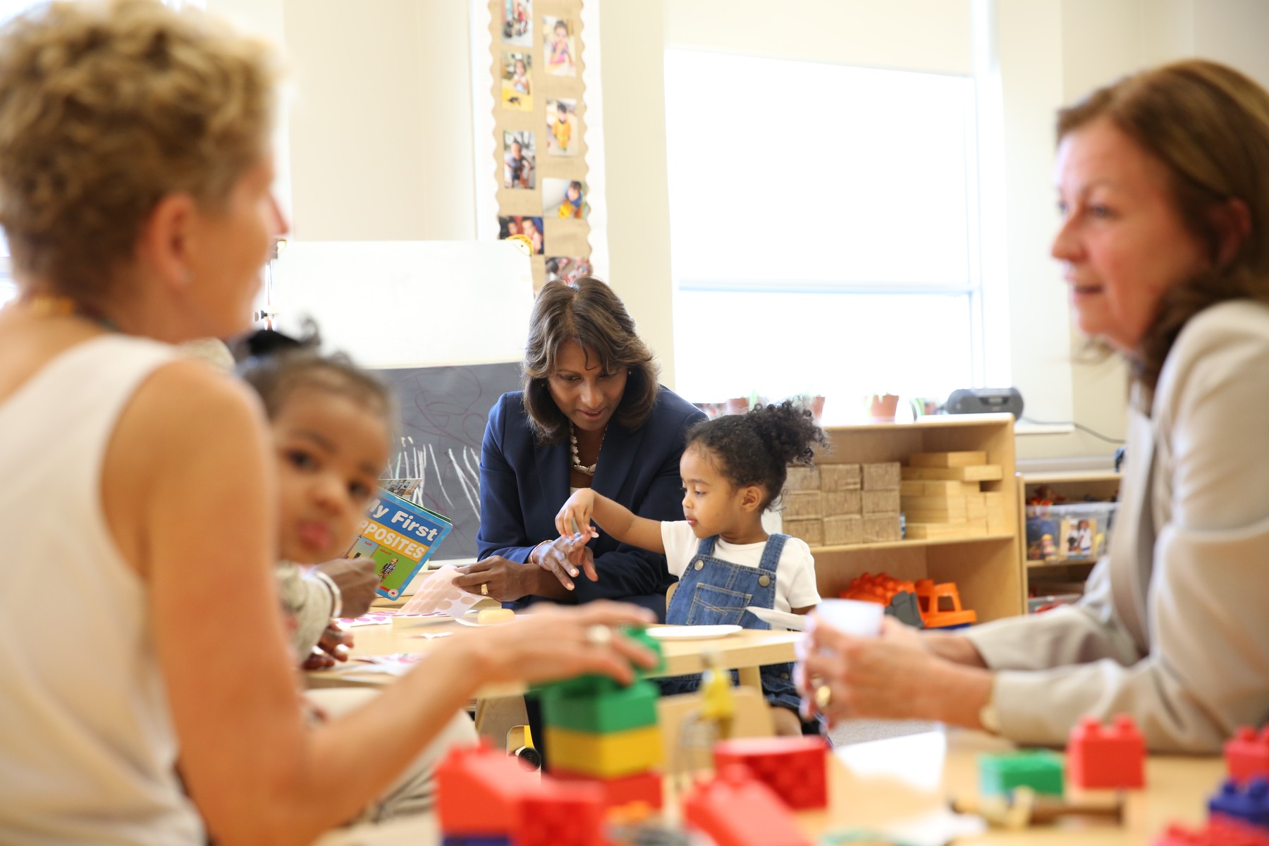 Indira Naidoo-Harris working with a child in a class | Province of Ontario