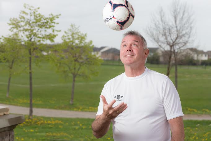 Kevin Flynn in a T-Shirt throwing a ball in the air, in a park | Liberal Party of Ontario, Oakville Riding