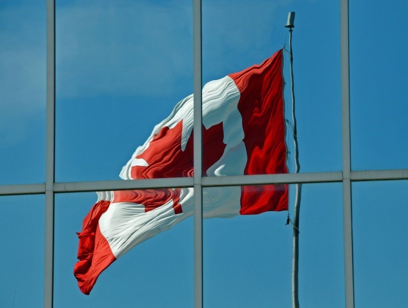 Canadian Flag waving reflected off mirrored building