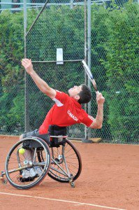 White male athlete playing tennis from wheel chair