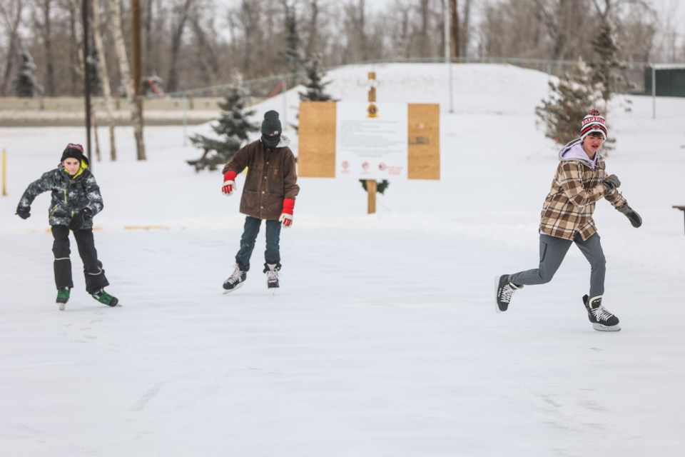 (L-R) James Penner, Marshall Kitchen, and C Morris take to the ice at the new skating rink created by community volunteers at the Lions Campground in Black Diamond on Jan. 7. 