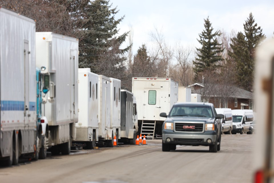 Production vehicles and crews for HBO's "The Last of Us" line Robinson Drive in Okotoks, Alta. on Feb. 10, 2022.
