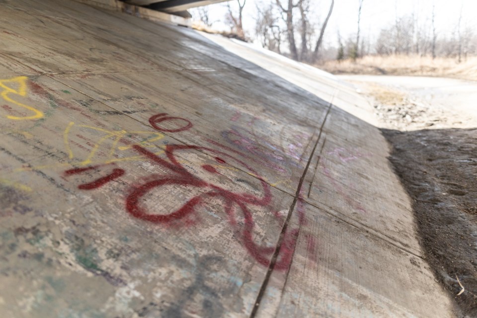 Graffiti adorns the south footings of the bridge joining Northridge and Southridge Drive on March 25.