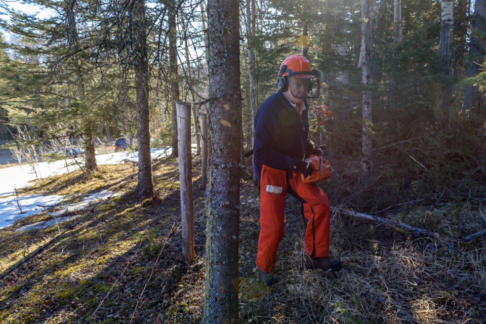Peter Spear, of the 300 Group Trail Maintenance Association, gets ready to clear fence line with a chainsaw on the northeast boundary of Brown-Lowery Provincial Park, north of Turner Valley on April 6, 2022. 