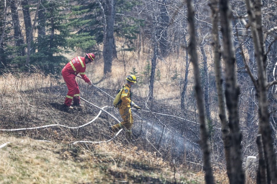Firefighters battle a brush fire west of Priddis on May 6. Priddis Greens FireSmart committee member John Robertson said that by becoming FireSmart, the community is trying to manage and reduce the risk of forest fire.