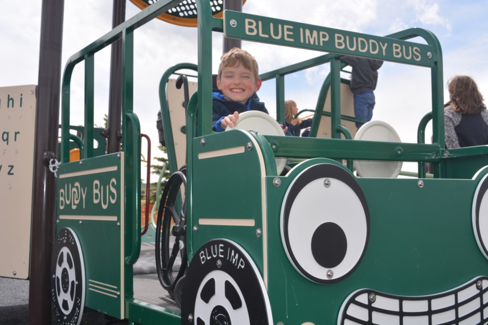 A Grade 3 student who uses a wheelchair enjoys the new 'Buddy Bus' at the Red Deer Lake School playground on May 18. 