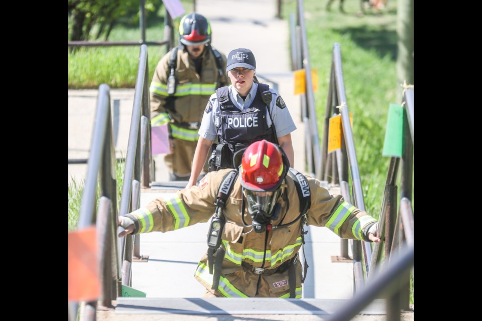 Okotoks RCMP Const. Bethany Simpson and firefighters Ian McLeod (front) and Ryan Kaiser climb the Clark Avenue stairs for the eighth annual Firefighter Stair Climb Challenge on June 2. For the second year, Okotoks responders completed the challenge remotely, using the stairs at Clark Avenue and Elma Street.