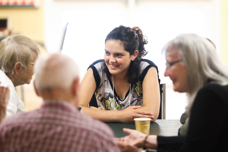 Volunteer Valentina Flores speaks with seniors living with dementia during a Memory Cafe session at the Okotoks & District Seniors Club on July 6.