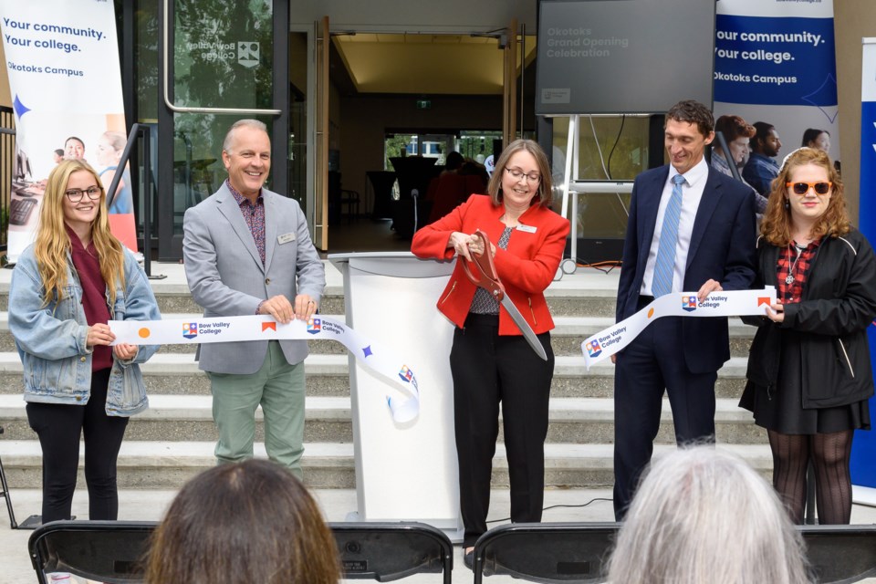 Students of Bow Valley College flank Brad Mauro, left, associate dean of regional stewardship, Leah Wack, centre, dean of regional stewardship, and Michael Crowe, right, VP academic, for a ribbon cutting to mark the grand opening of the expanded Bow Valley College regional campus in Okotoks on Sept. 22. 
