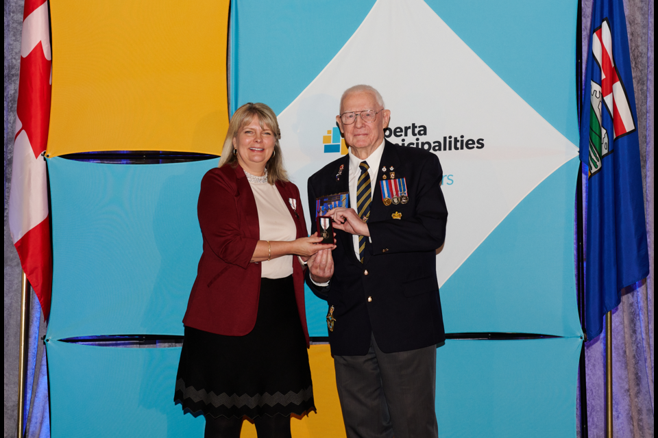 Malcolm Hughes, right, is presented with a Queen Elizabeth II Platinum Jubilee Medal during a ceremony in Calgary on Dec. 4. Hughes was among 10 recipients from the Foothills who were awarded the medal that day.
