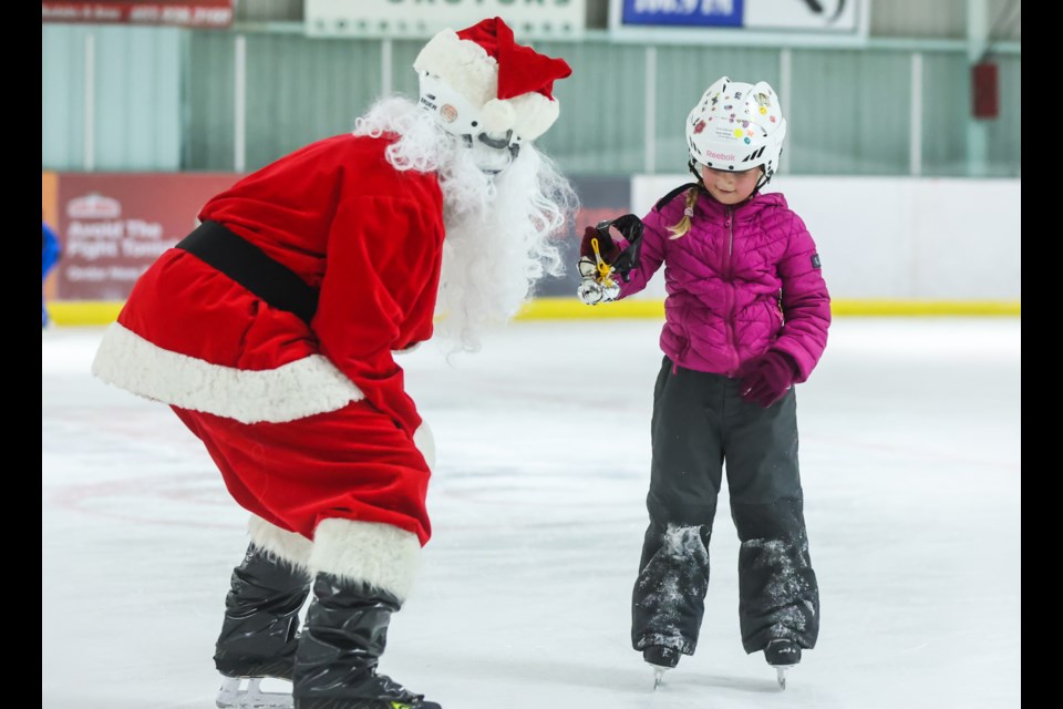 Sloan Selman tries jingling the sleigh bells during the Skate with Santa event at Piper Arena on Dec. 11.