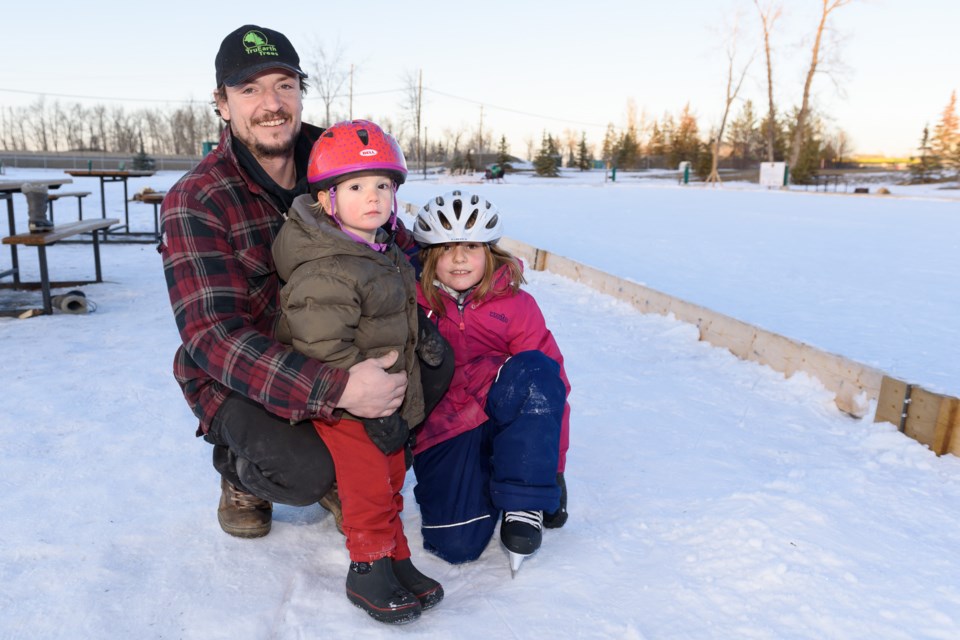 Colin Baustad, left, spending time with his kids Lachlan, centre, and Hailey at the skating rink at the Lions Campground in Diamond Valley on Jan. 4. 