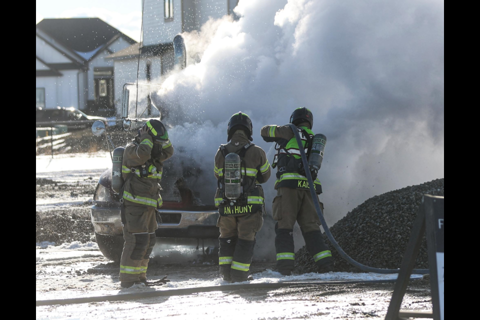 Crews work to extinguish a dump truck on fire in the Cimarron neighbourhood Wednesday. 