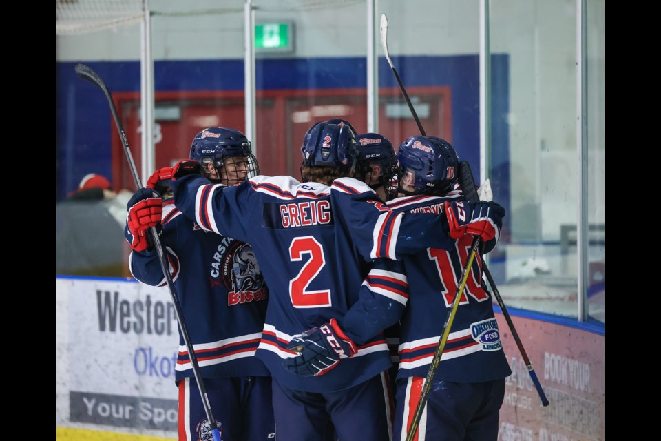 The Okotoks Carstar Bisons celebrate a goal by forward Easton Dean during the Game 2 win over Strathmore on Feb. 24 at the Murray Arena. Okotoks swept the best-of-seven series in four games to advance to the HJHL Southern Division final.
