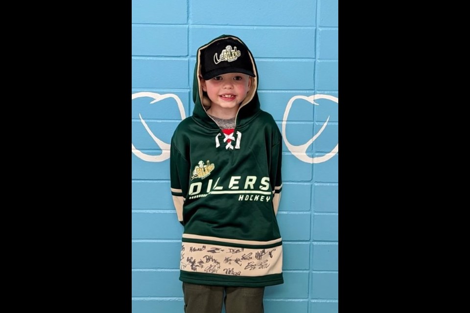 Seven-year-old Coen Eckel shows off his Okotoks Oilers hoodie signed by all the players. 