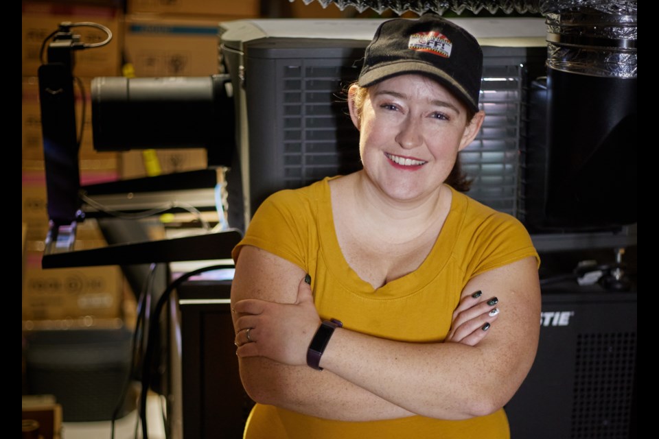 Katie Fournell, festival director for the Okotoks Film Society, poses in the projector room at Okotoks Cinemas on March 23, 2023.