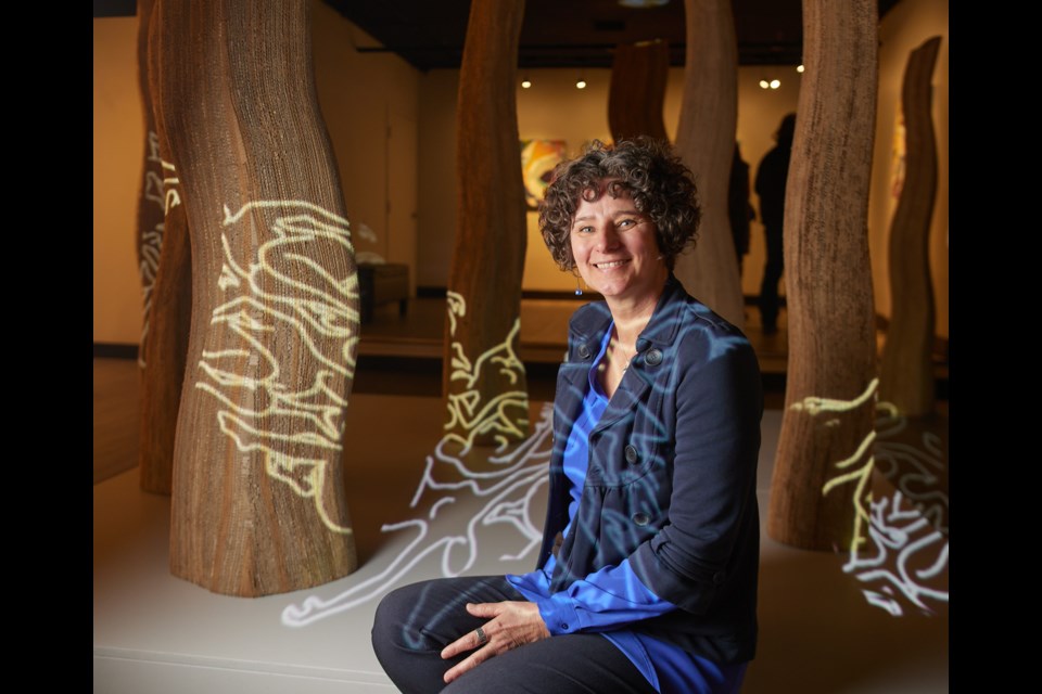 Patricia Lortie poses among the various 3D and 2D components of her exhibition 'The Keepers' at the Okotoks Art Gallery on April 15.