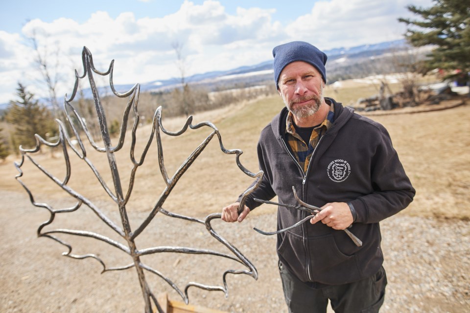 Blacksmith James Greisinger stands with his statue, dubbed 'Forged Community' at his Millarville-area property on April 13. Portions of the statue were forged by frontline workers such as doctors, nurses, teachers and first responders.