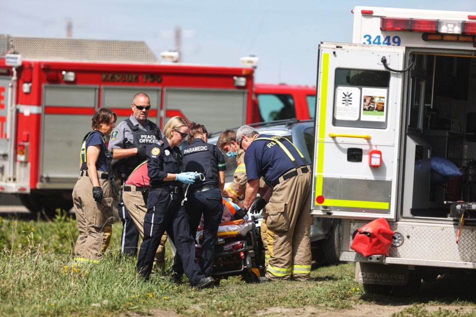 First responders work to extricate an injured man from a single-vehicle collision on Highway 22 in the centre of Diamond Valley on May 24.